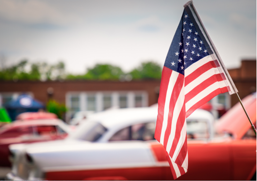American Flag with cars in background